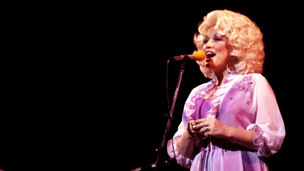 Dolly Parton śpiewa do mikrofonu podczas koncertu